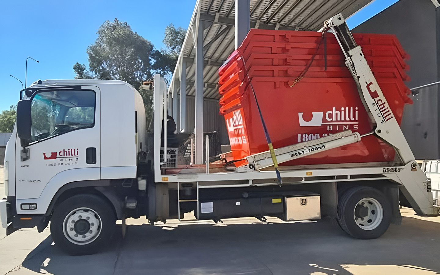 Red Flatbed Truck Loaded With Stacked Red Skip Bins — Chilli Bins Skip Bins in Redcliffe, QLD