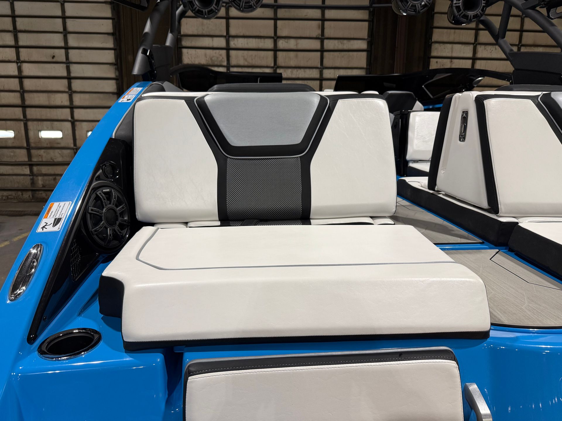 Blue and white boat interior with padded seats and speakers.