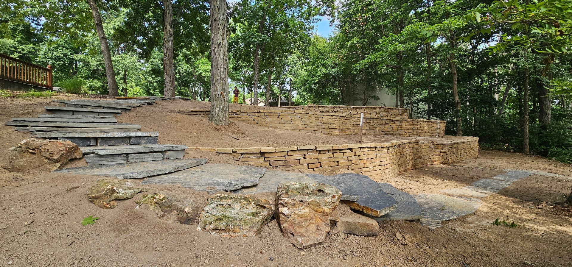 A brick house with a newly landscaped front yard, featuring mulch, rocks, and plants.