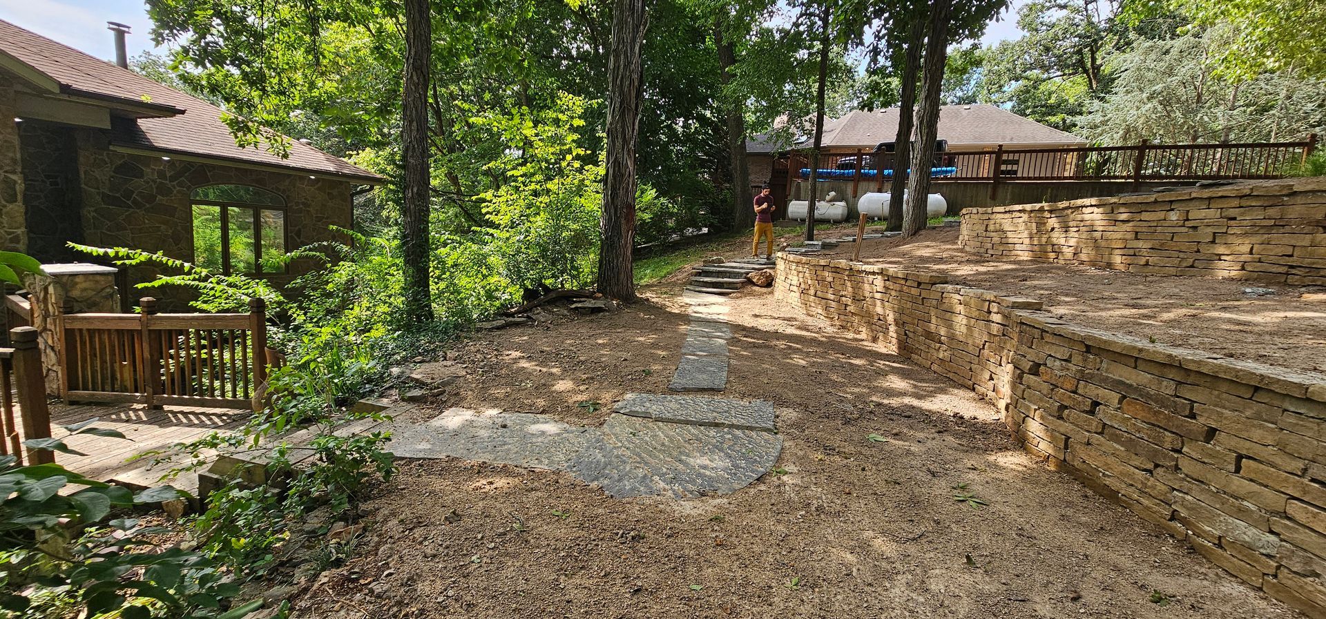A brick house with a newly landscaped front yard, featuring mulch, rocks, and plants.