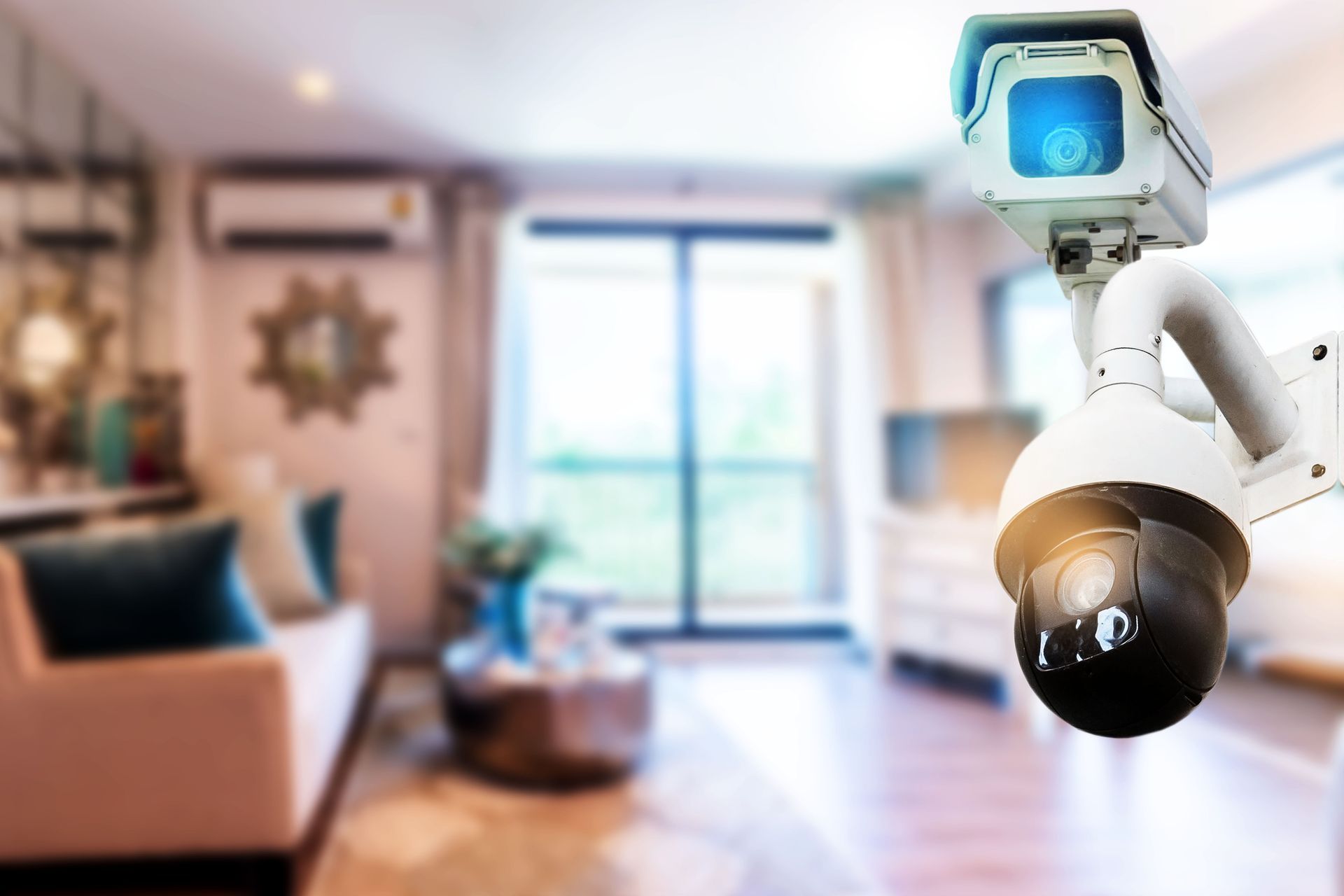 A security camera is hanging from the ceiling in a living room.