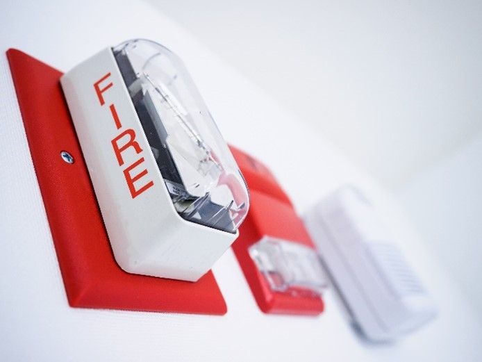 A red and white fire alarm with the word fire on it