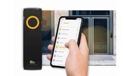 A person is holding a cell phone in front of a door.