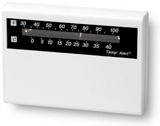 A white thermostat with a black label that says temp alert