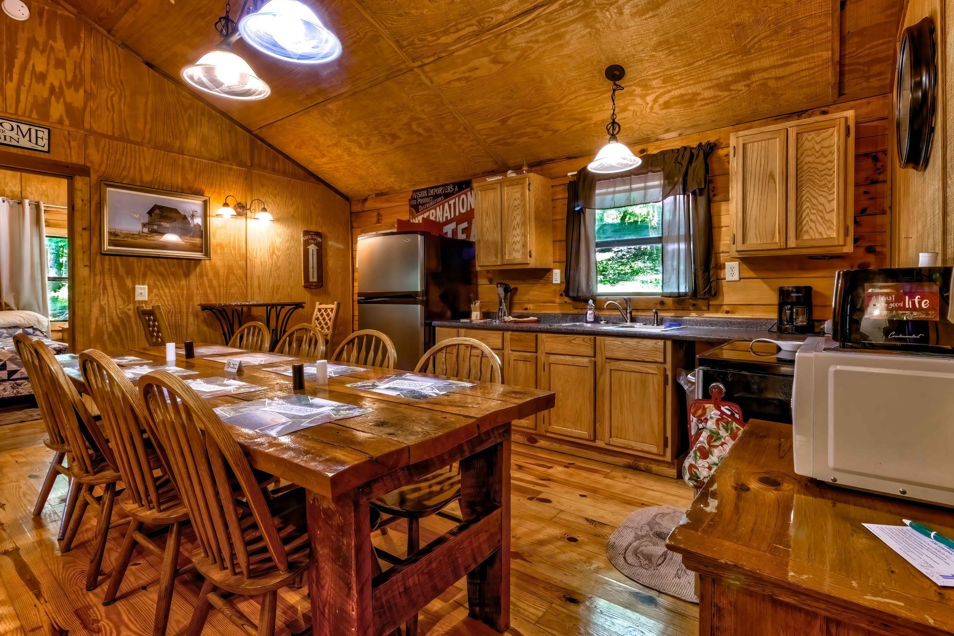 Cozy wood-paneled dining room with a table, chairs, cabinets, and kitchen appliances