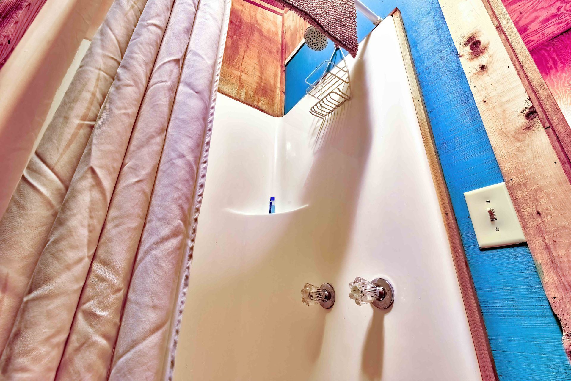 Shower stall with beige curtain, white door, and blue trim in a bathroom
