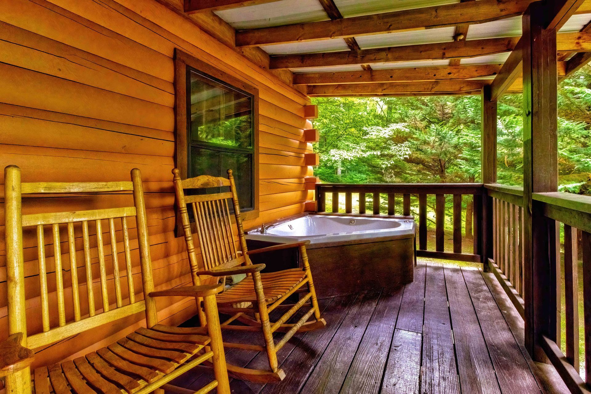 Wooden cabin porch with rocking chair, round table, and forest view