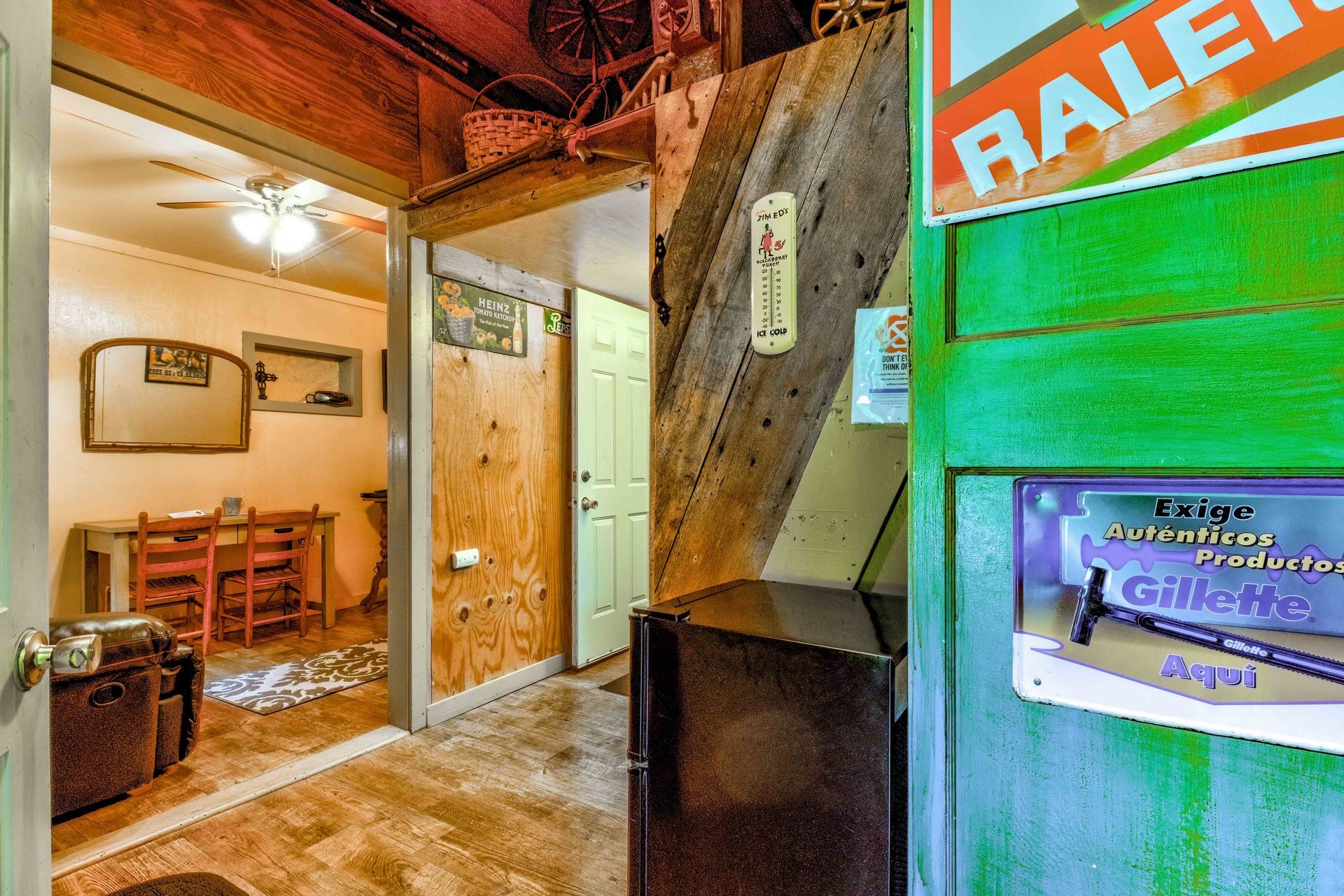 Rustic indoor hallway with wooden doors, a desk, and a green wall with a real estate sign.