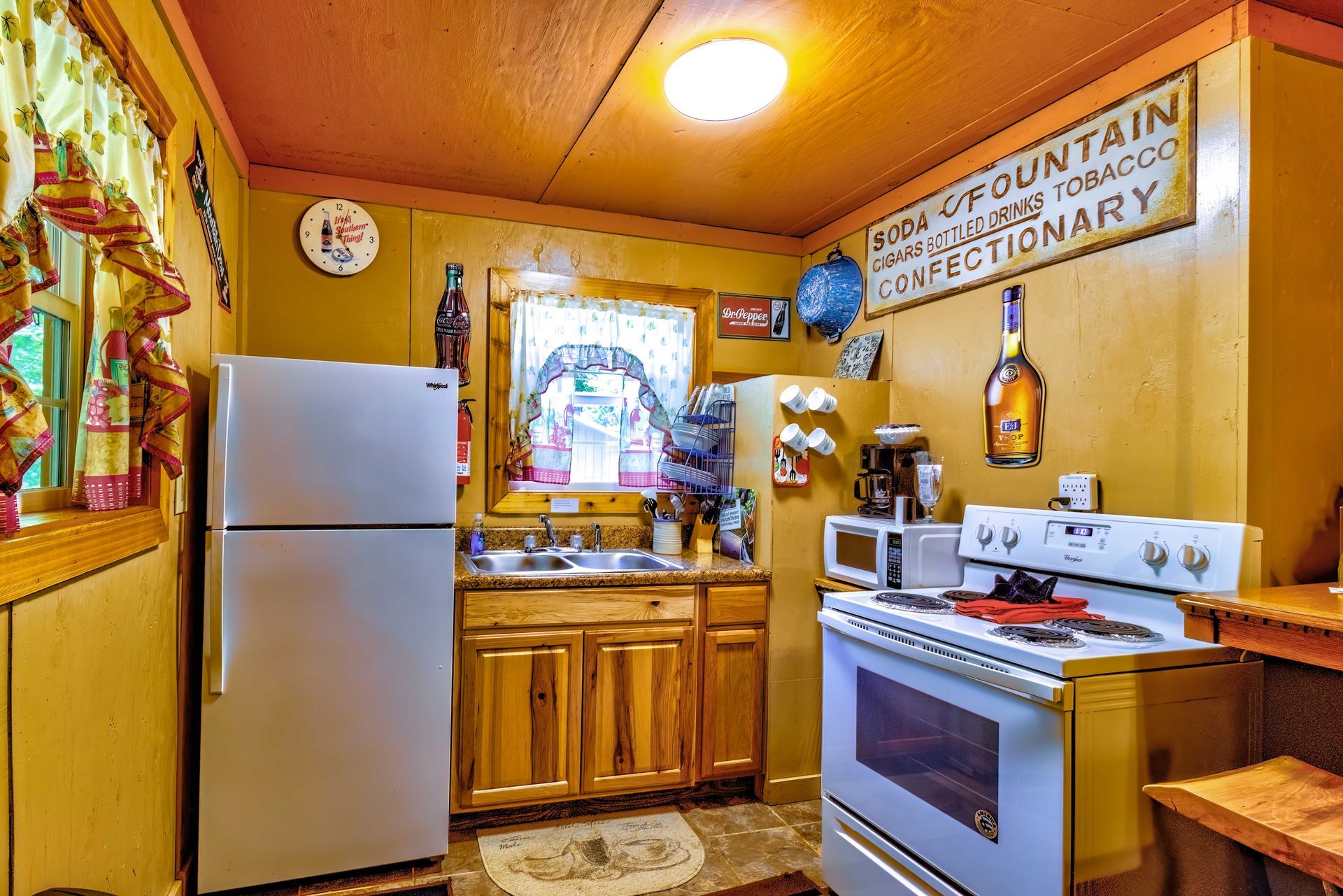 Cozy rustic kitchen with white fridge, stove, wooden cabinets, and a window above the sink