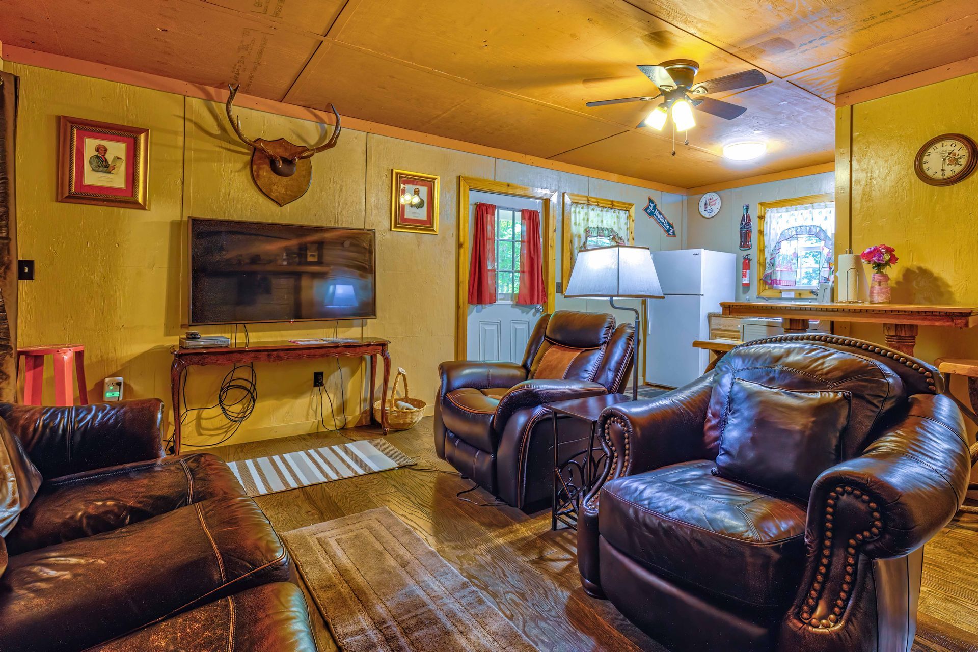 Cozy living room with leather recliners, wall-mounted TV, and warm yellow walls