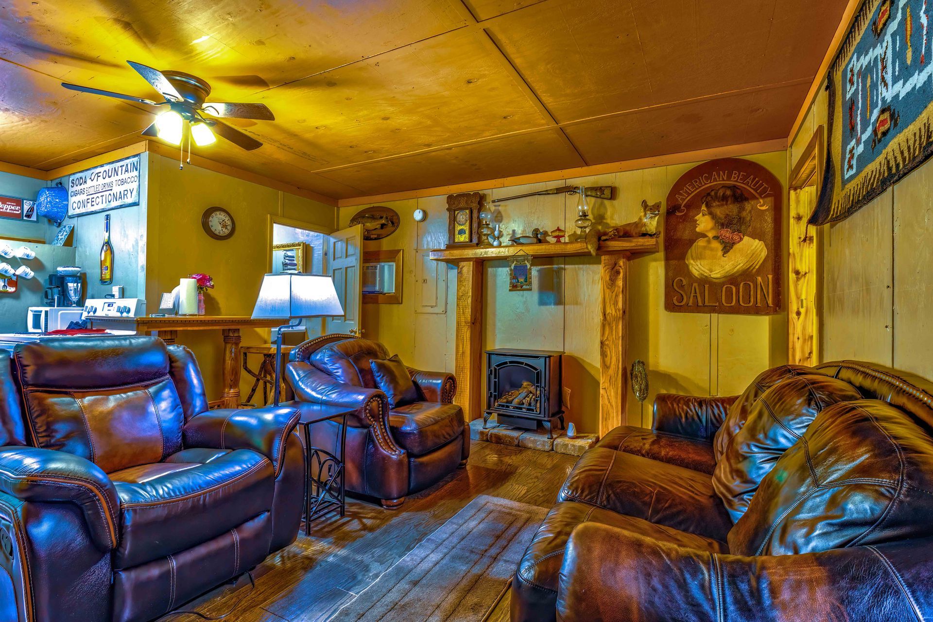 Cozy living room with brown leather recliners, fireplace, ceiling fan, and warm yellow walls