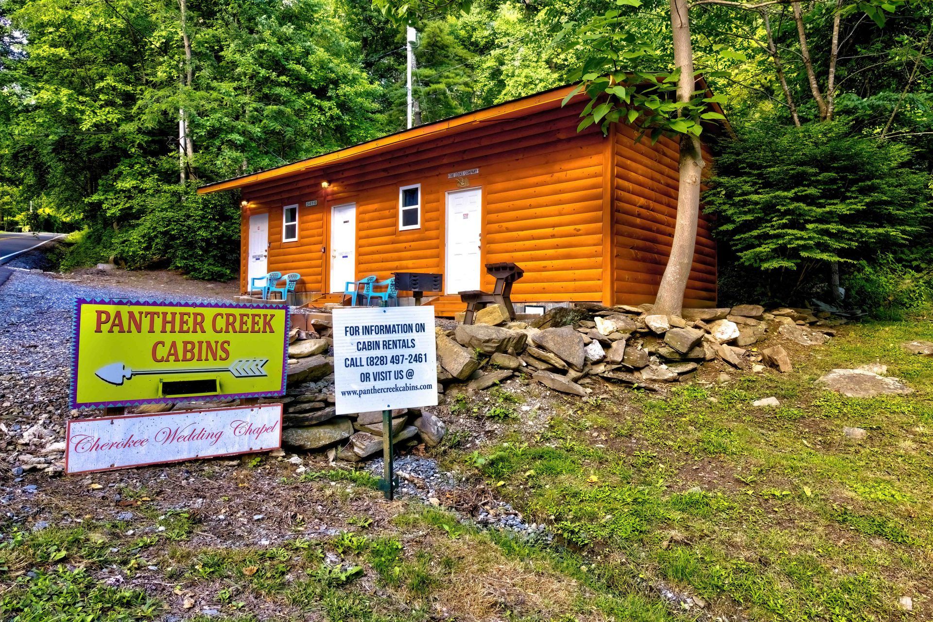 Panther Creek Cabins sign beside a small orange cabin in a wooded area