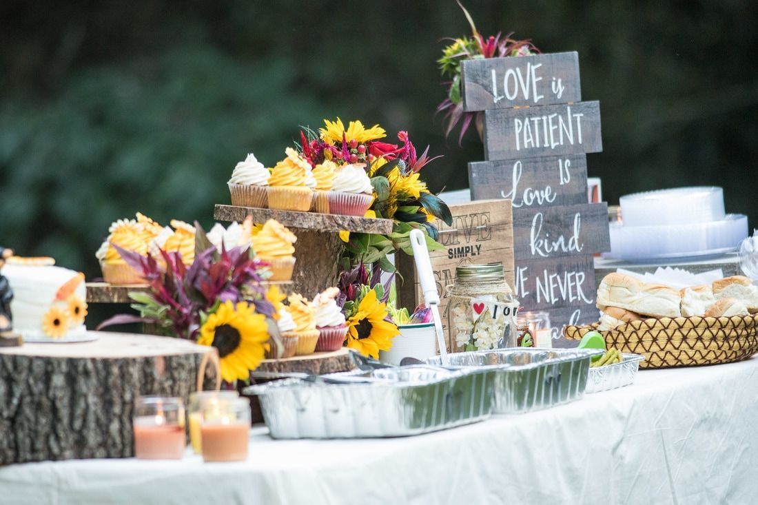 Rustic dessert table with cupcakes, sunflowers, candles, and a chalkboard sign for a retirement celebration