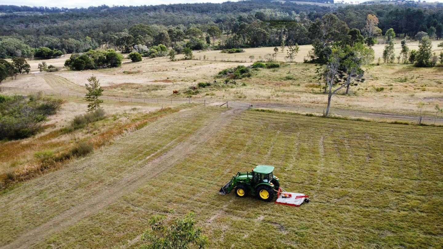 An aerial view of a tractor cutting grass in a field. — Hilltop Property Services In Crows Nest, QLD 