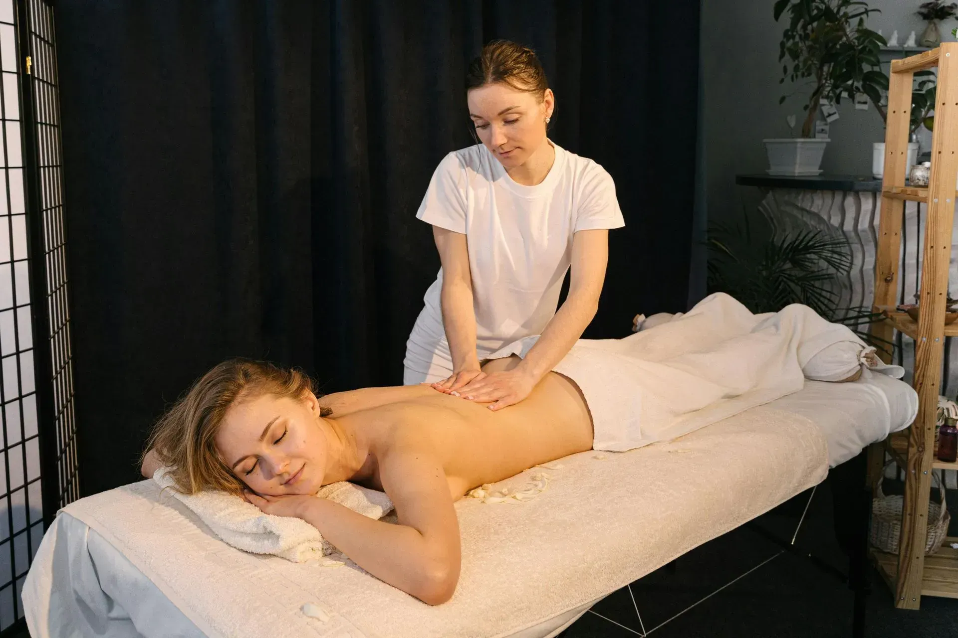 Mobile massage therapist treating a client at home.