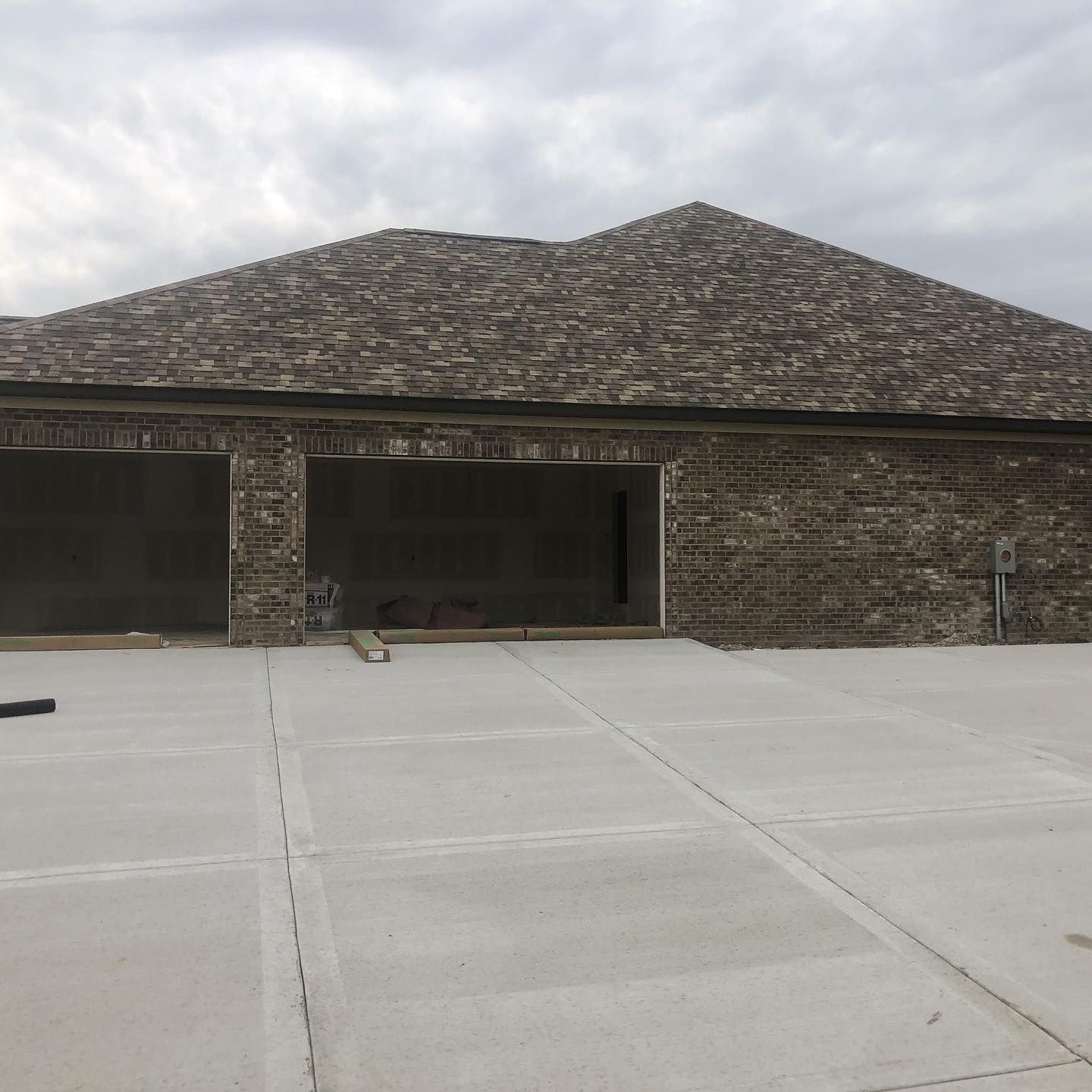 A brick house with a concrete driveway in front of it