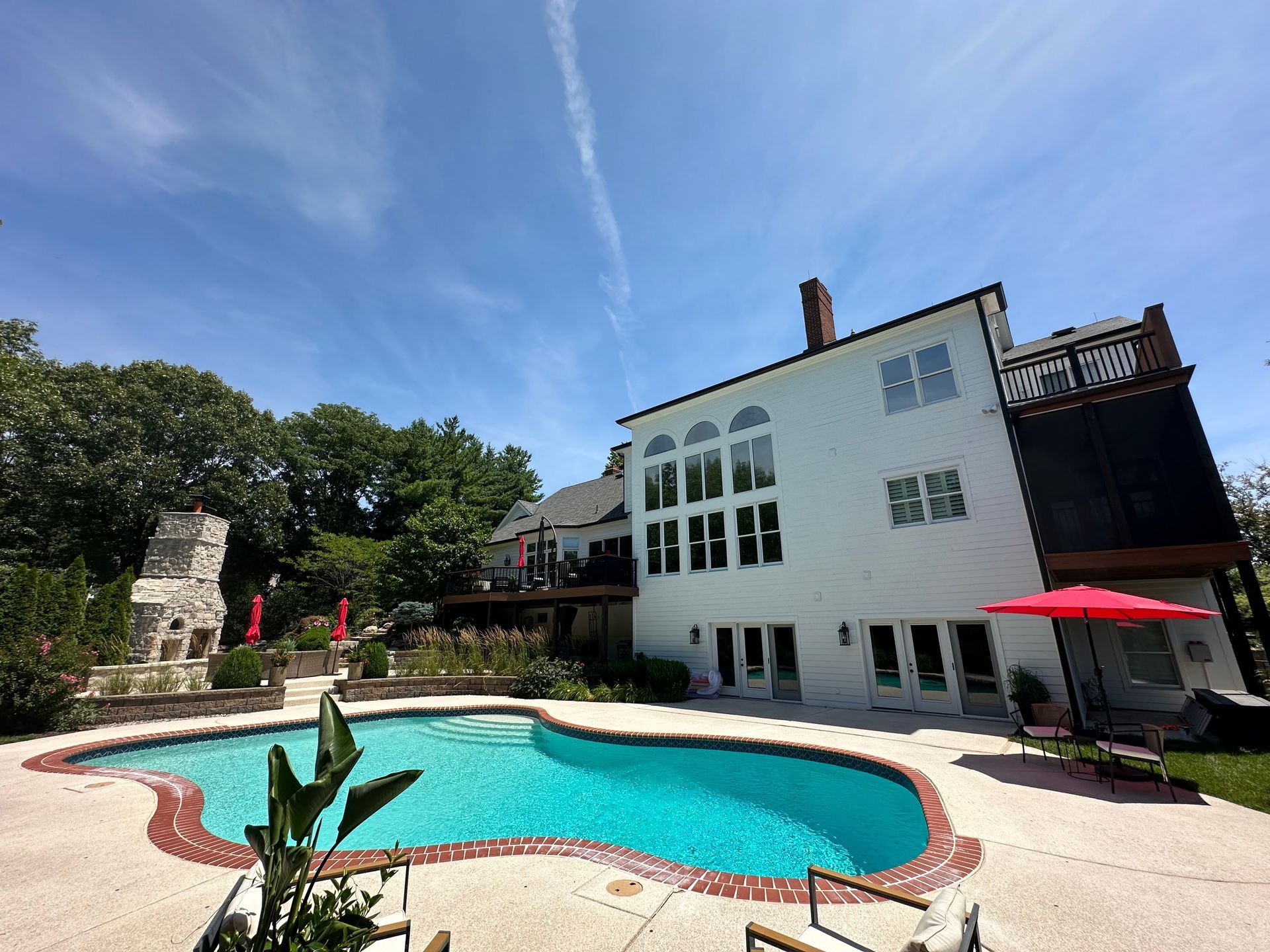 A large white house with a large swimming pool in front of it