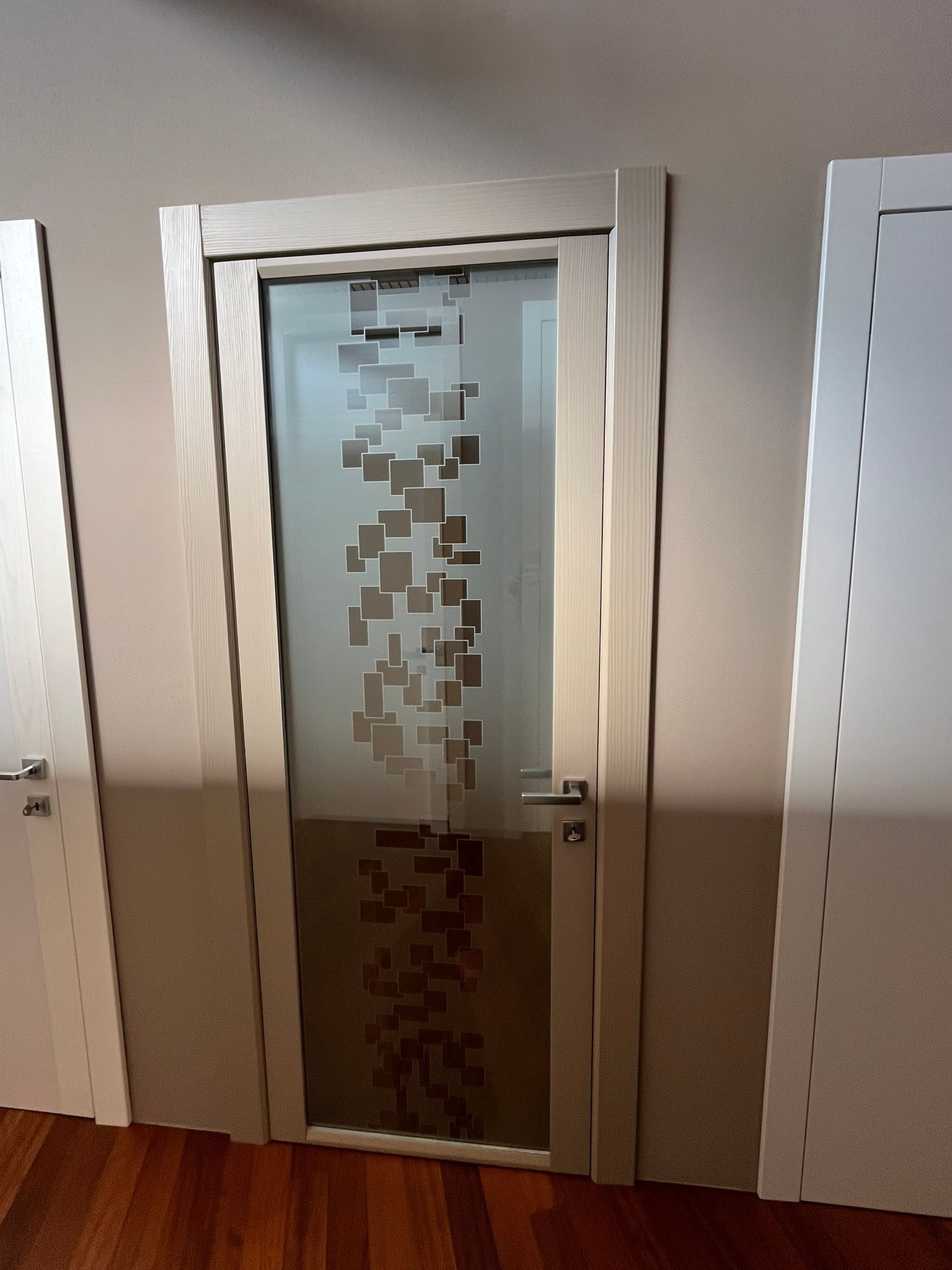 Porta in vetro satinato con motivo a pixel per la privacy in un corridoio