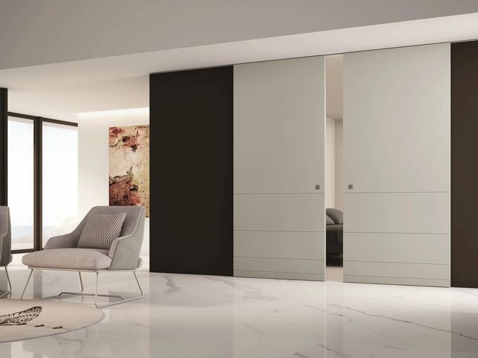 Soggiorno moderno e minimalista con poltrona grigia, pavimento in marmo bianco e ante scorrevoli dell'armadio.