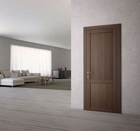 Soggiorno moderno con divano grigio, ampia finestra luminosa e porta in legno in un interno minimalista