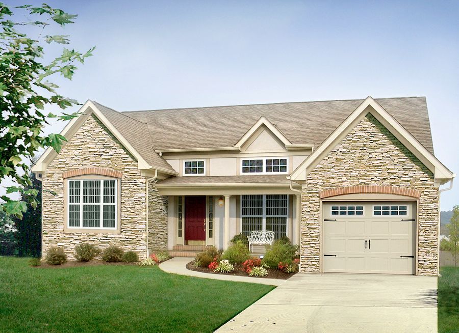 A house with a stone facade and a tan garage door
