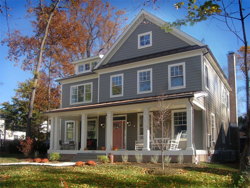 A large gray house with a large porch
