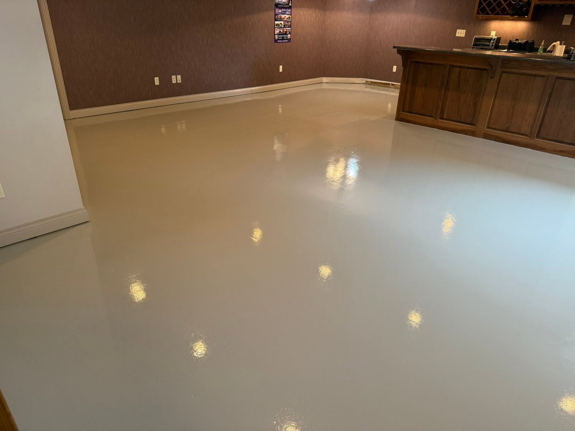 Empty glossy floor in a room with brown walls and a wooden counter