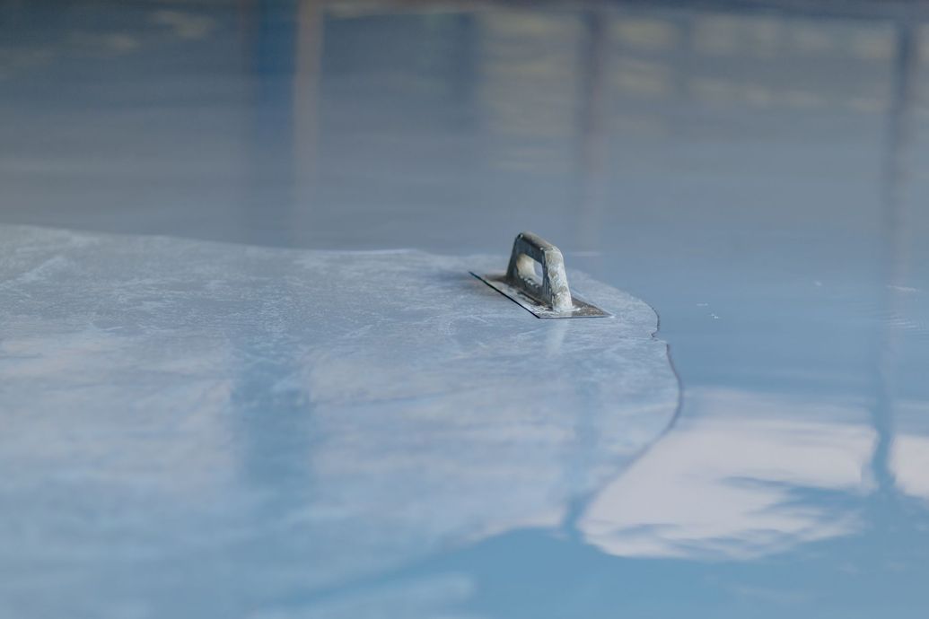 Small metal ring embedded in a blue icy surface with a cracked edge nearby