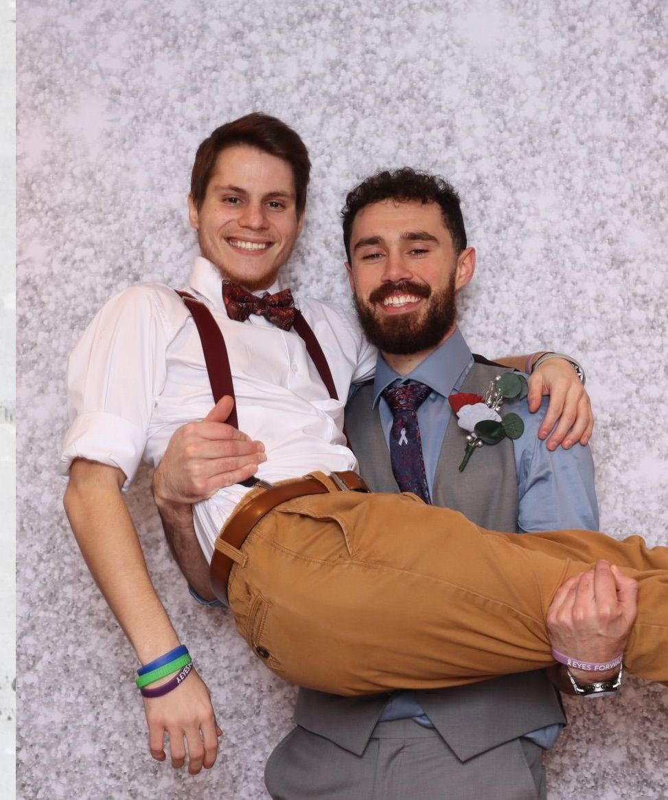 A man is holding another man in his arms