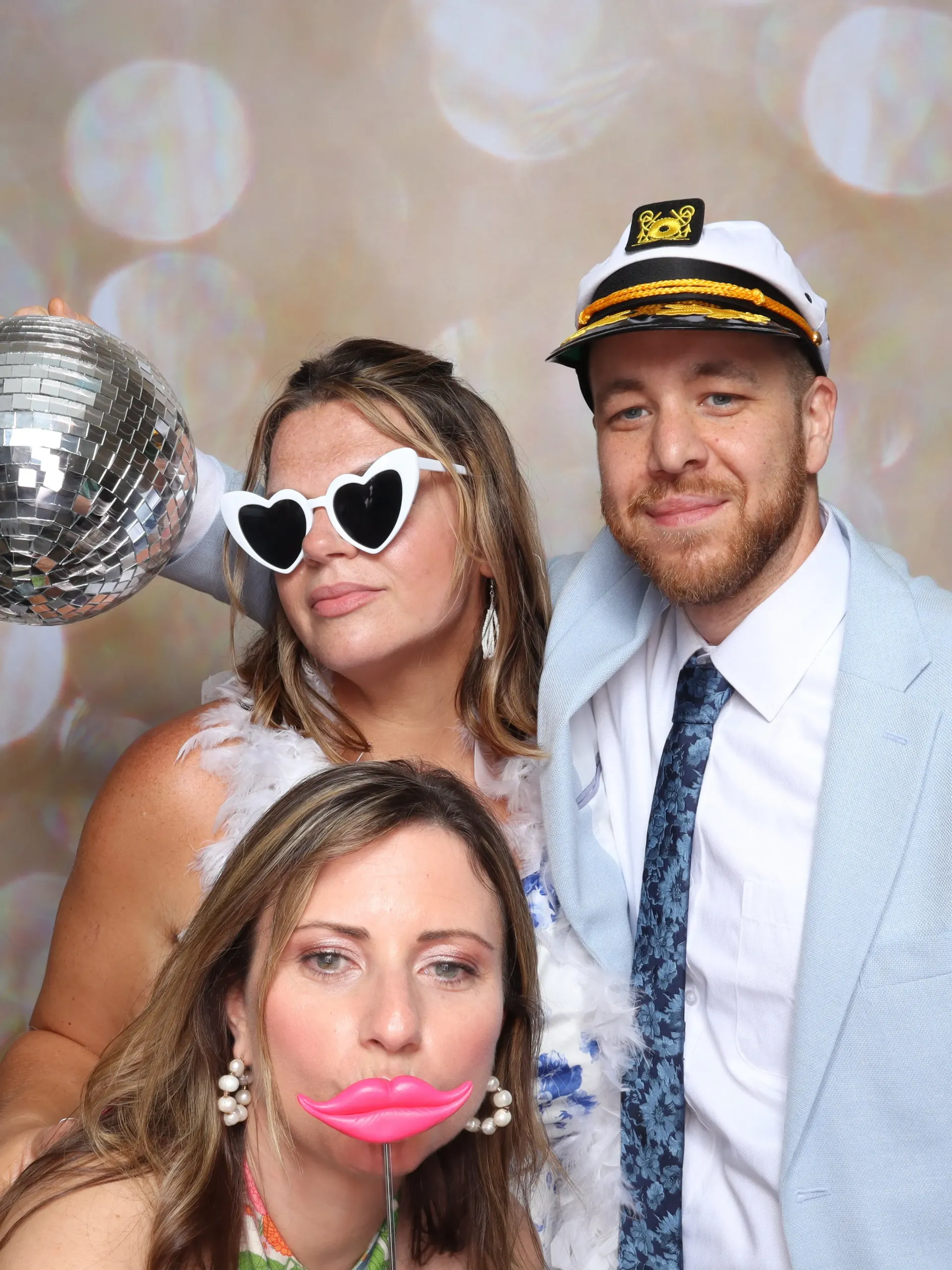 Married couple and their daughter posing for a picture in a photo booth.