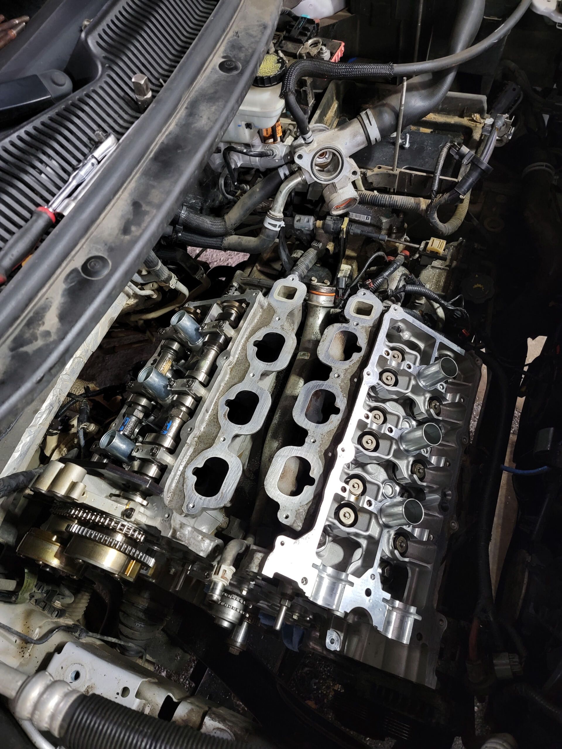 Engine with cylinder head removed, showing exposed valves and oil-covered components.