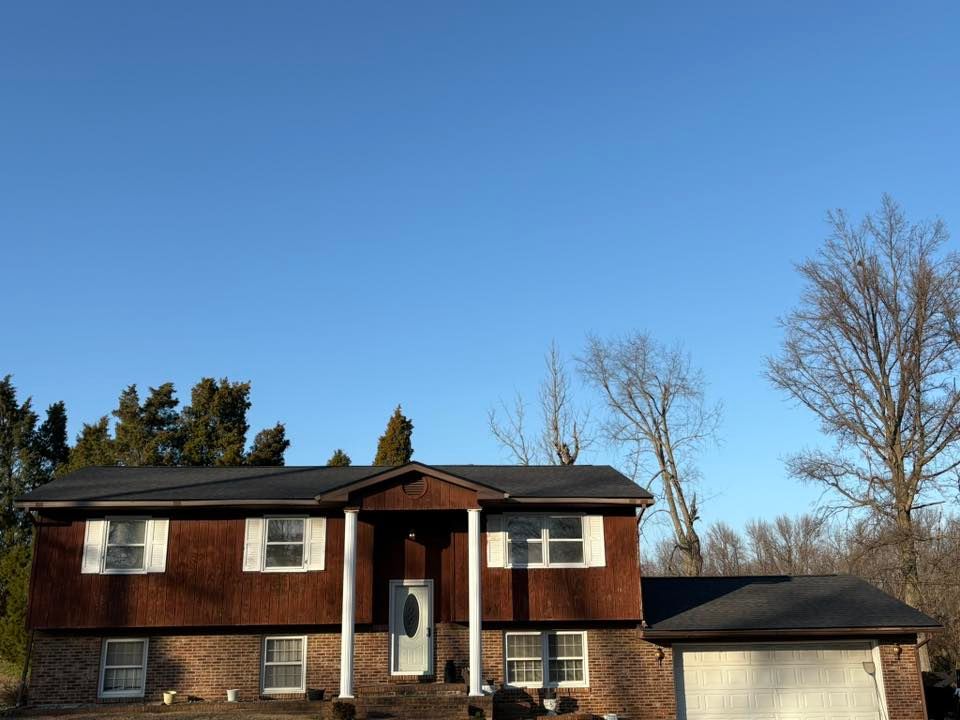 Suburban two-story brown house with a garage under a clear blue sky