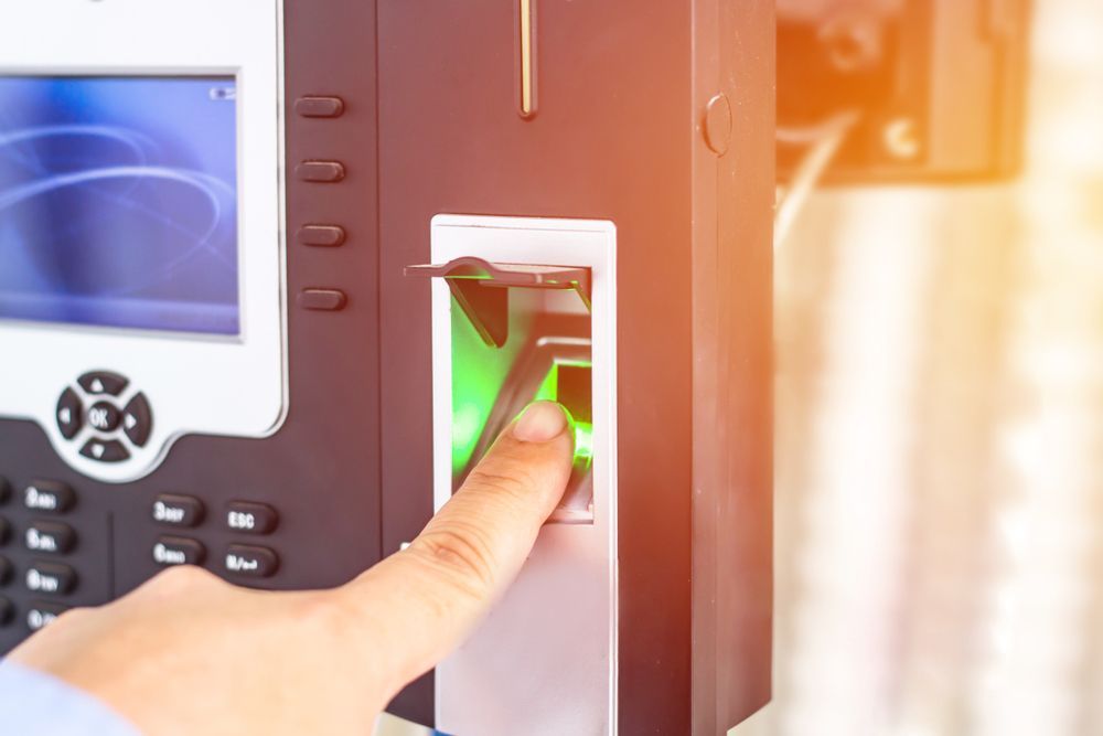 Finger Scanning on a Black Biometric Device; Hand Placing Finger on a Green-lit Scanner — IRIS CCTV in Tenterfield, NSW