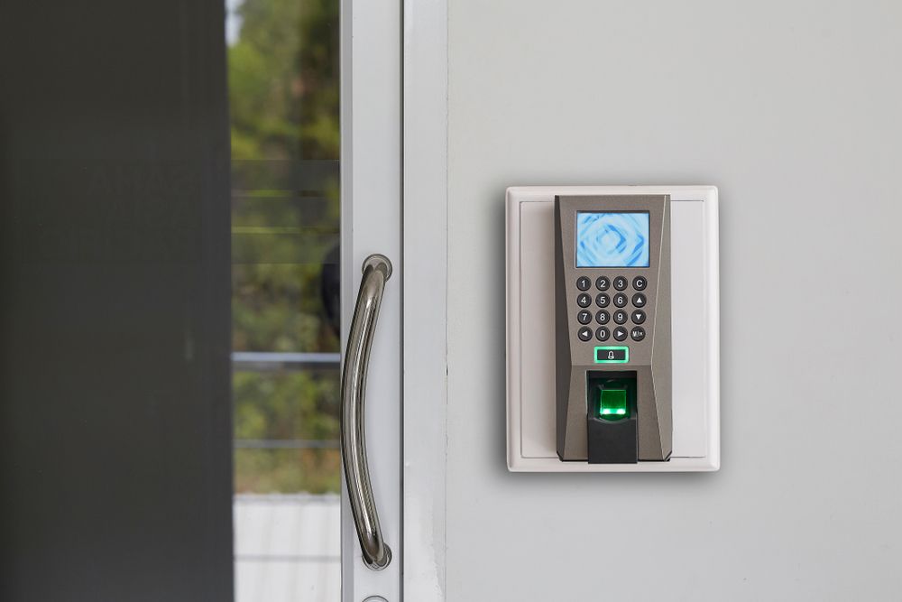 A Fingerprint and Keypad Access Control System Mounted on a White Wall Next to a Door — IRIS CCTV in Yamba, NSW