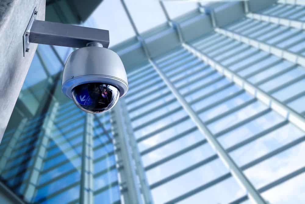 Security Camera Mounted on Wall, Capturing a Modern Glass Building— IRIS CCTV in Grafton, NSW