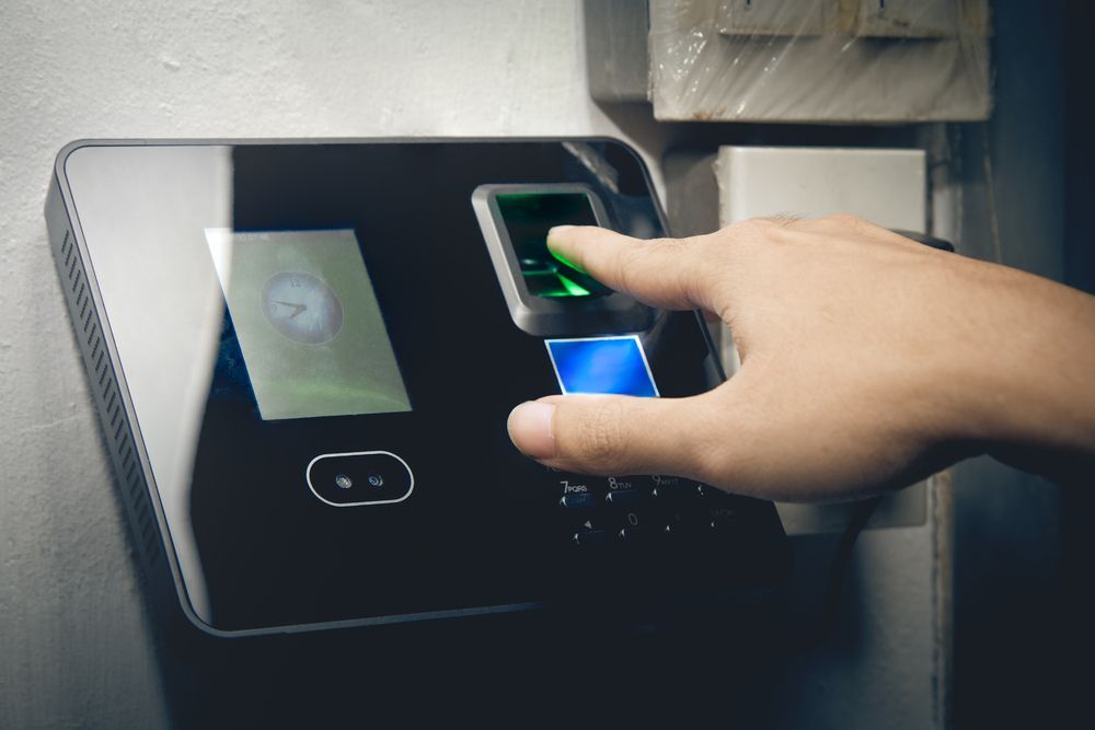 Person Uses Fingerprint Scanner for Time Clock on a Wall — IRIS CCTV in Ballina, NSW