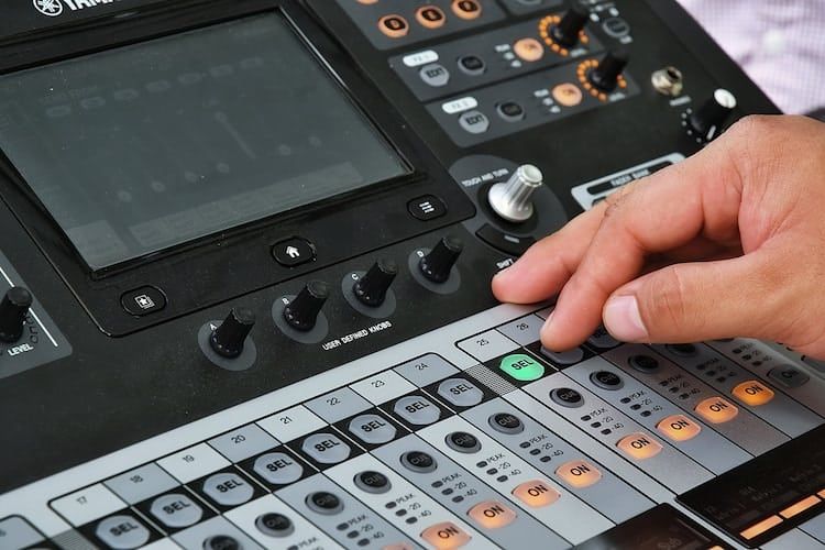 Hand Pressing a Button on a Digital Audio Mixing Console. the Console Has a Screen, Knobs, and Faders — IRIS CCTV in South Grafton, NSW