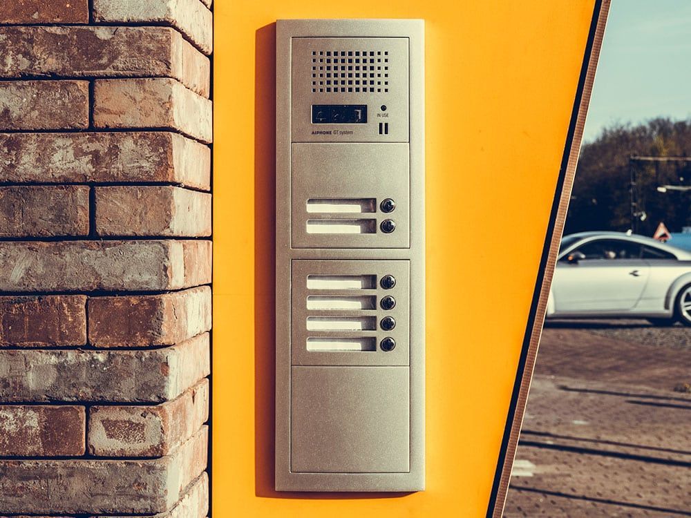 Intercom Panel on an Orange Wall Next to a Brick Column — IRIS CCTV in South Grafton, NSW