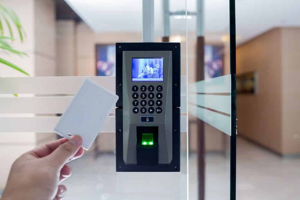 Hand Holding Access Card Near a Door Security System With Keypad, Fingerprint Reader, and Small Screen — IRIS CCTV in Port Macquarie, NSW