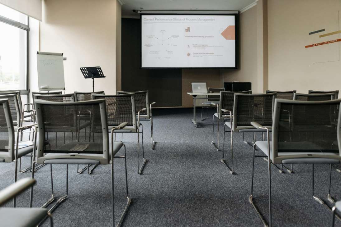 Empty Conference Room With Rows of Chairs, a Screen Displaying a Presentation, and a Whiteboard — IRIS CCTV in Ballina, NSW