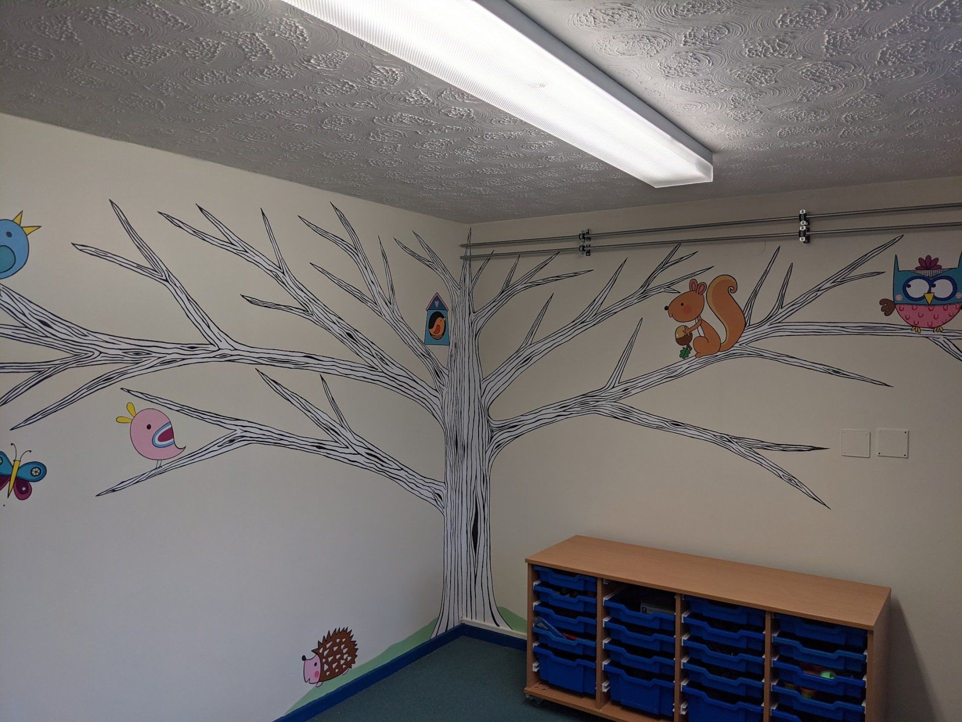 modern white tree mural with animals in a primary school