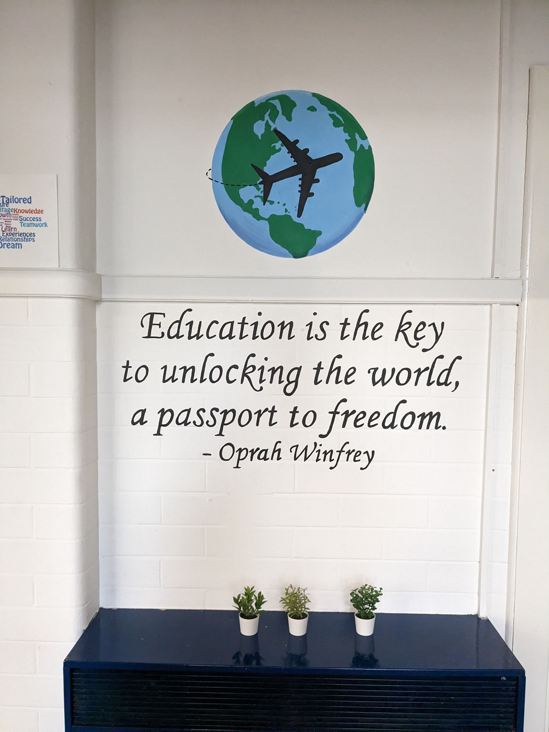 MURAL OF THE WORL WITH A AEROPLANE AND A QUOTE BELOW IN PRIMARY SCHOOL