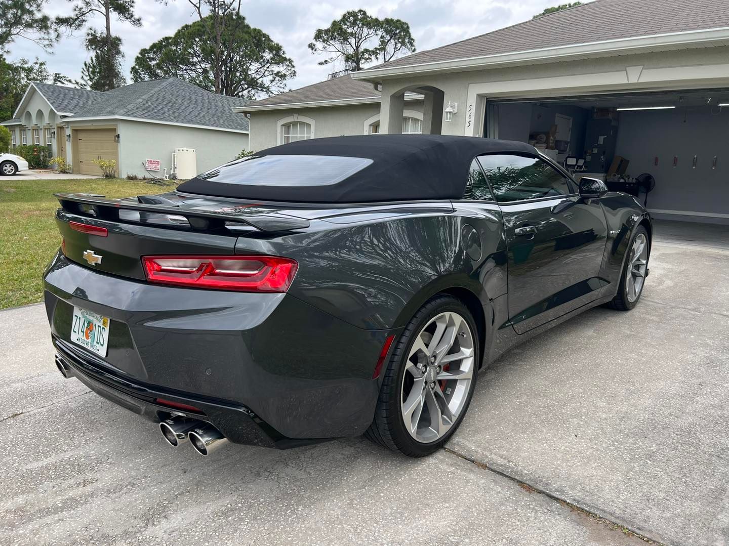 Dark gray convertible car parked in a driveway.