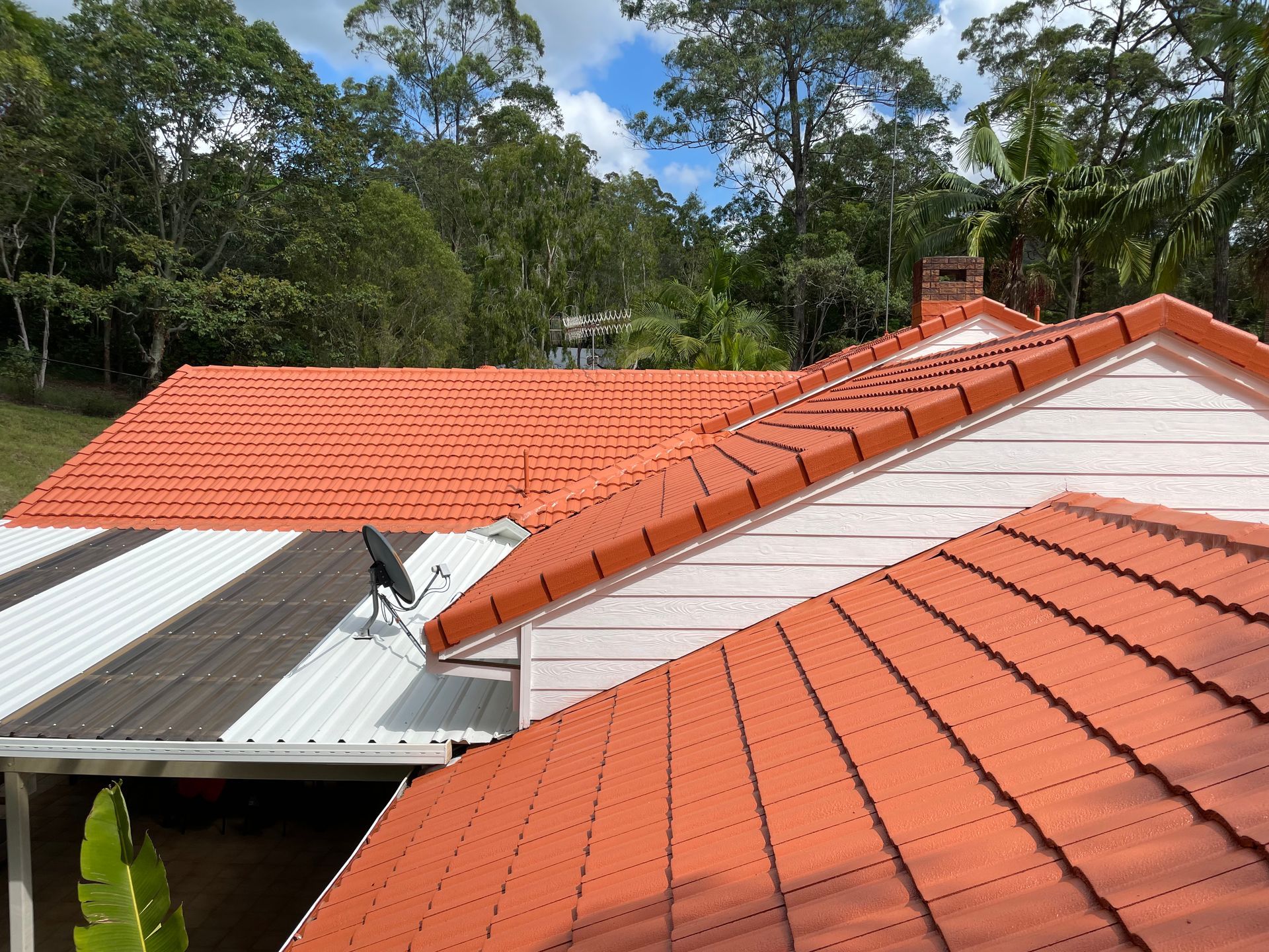 Painting roof in green Colors with paint spray gun — Roof Painting in Southport QLD