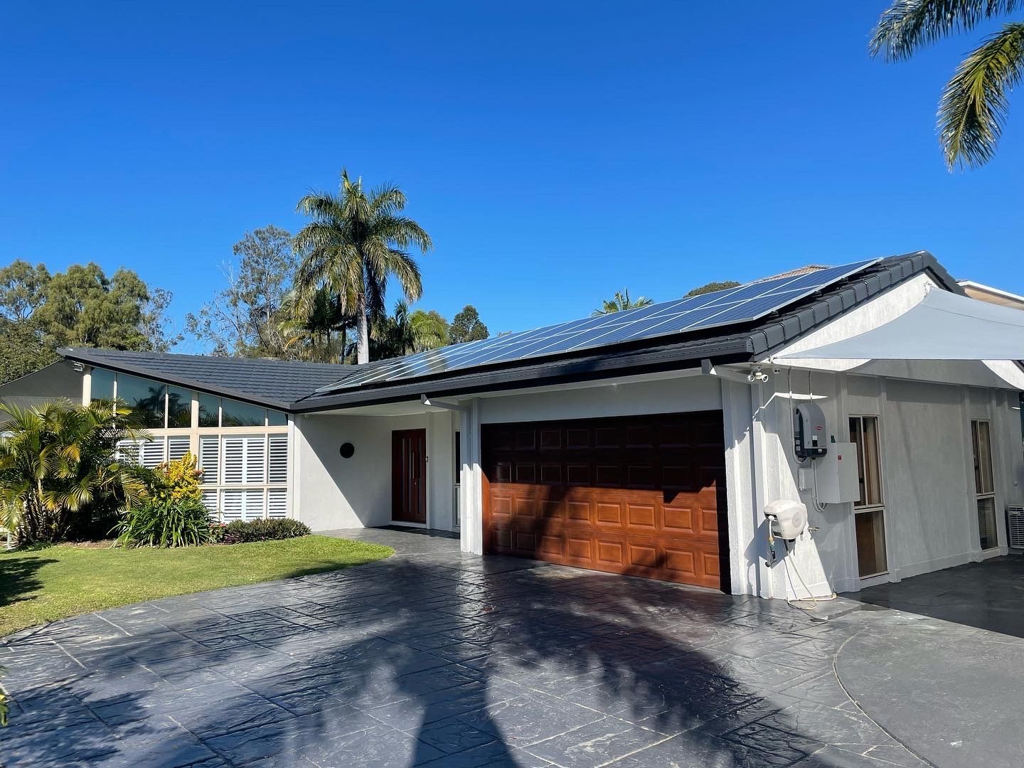 Black tile roof on a white house — Roofer in Southport QLD