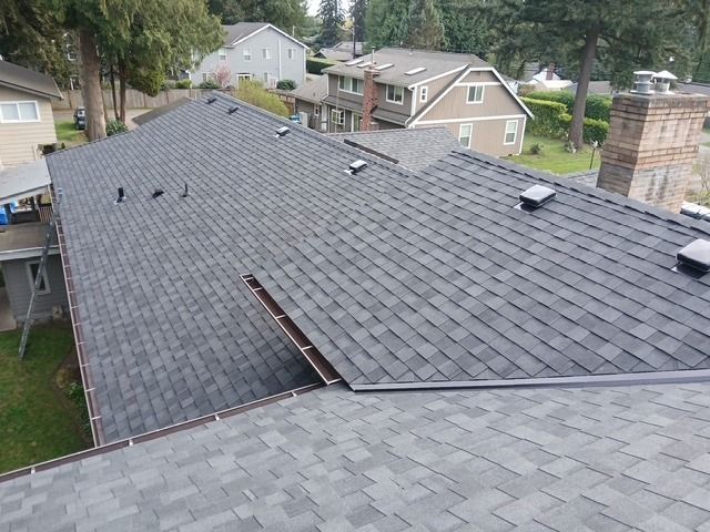 Roof damage with a large missing section of shingles on a suburban house