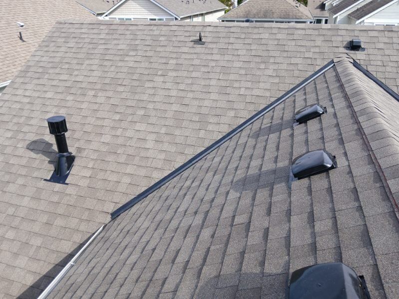 Residential shingle roof with vents and skylights, viewed from above