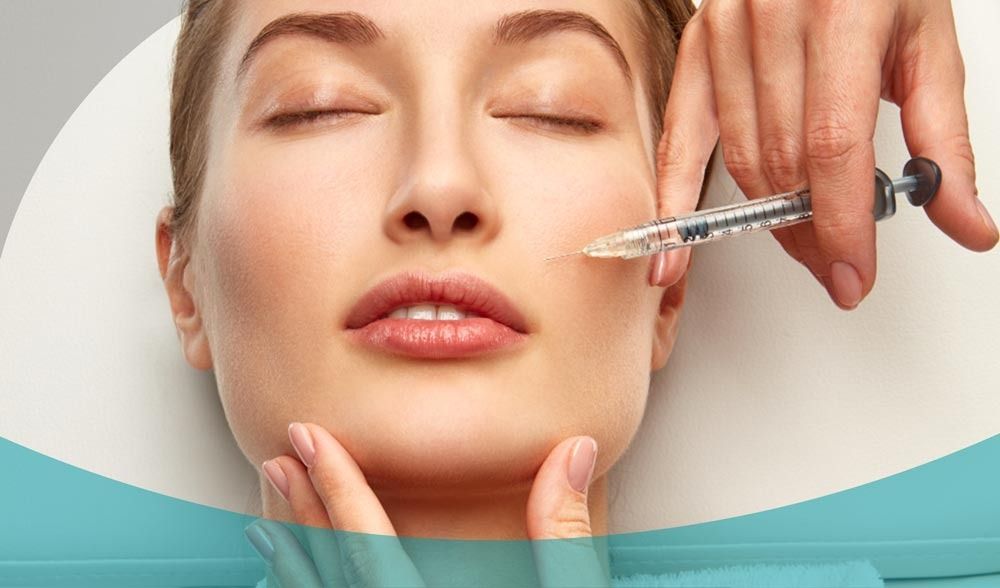 Un medico specializzato in medicina estetica somministra un'iniezione di filler dermico cosmetico nella zona delle guance di una persona.