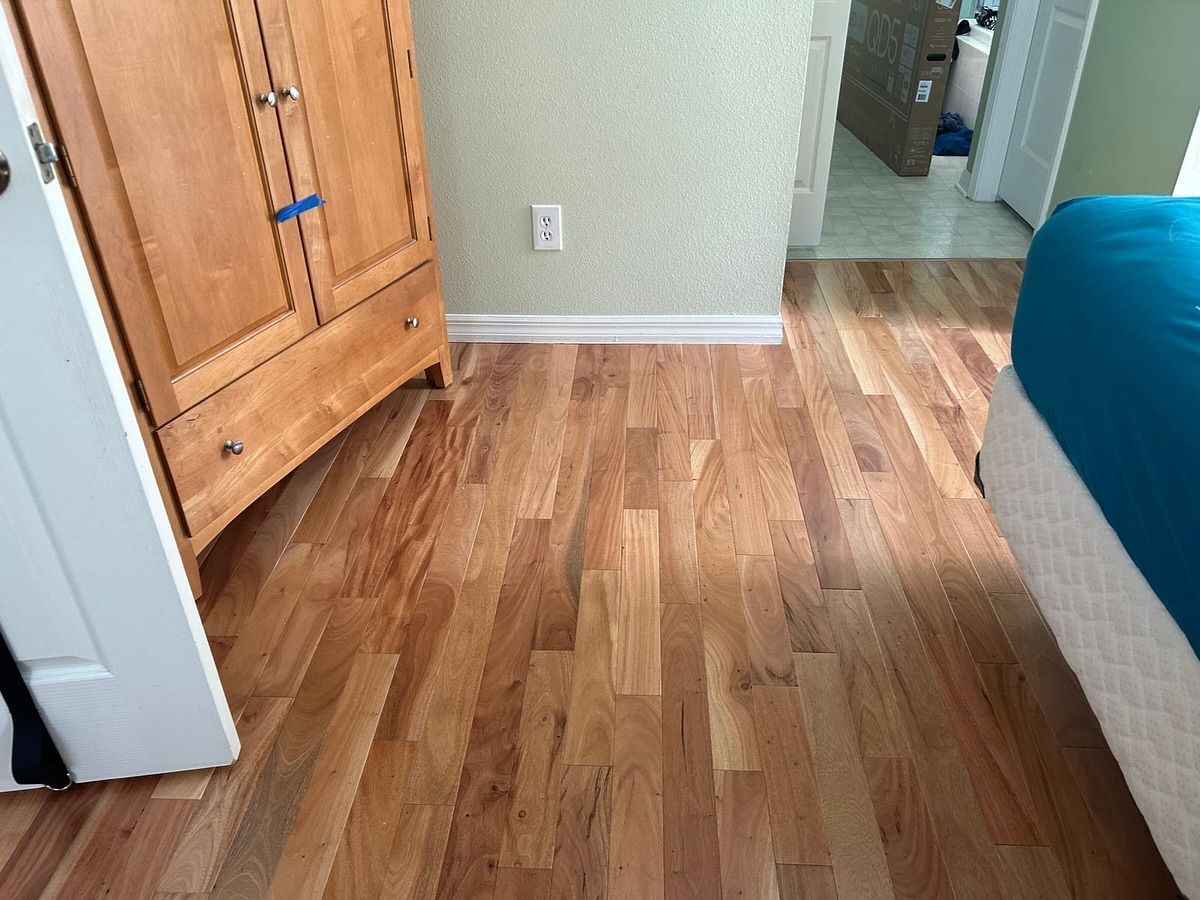 Wooden hallway with a wardrobe, light wall, and bed edge on the right.