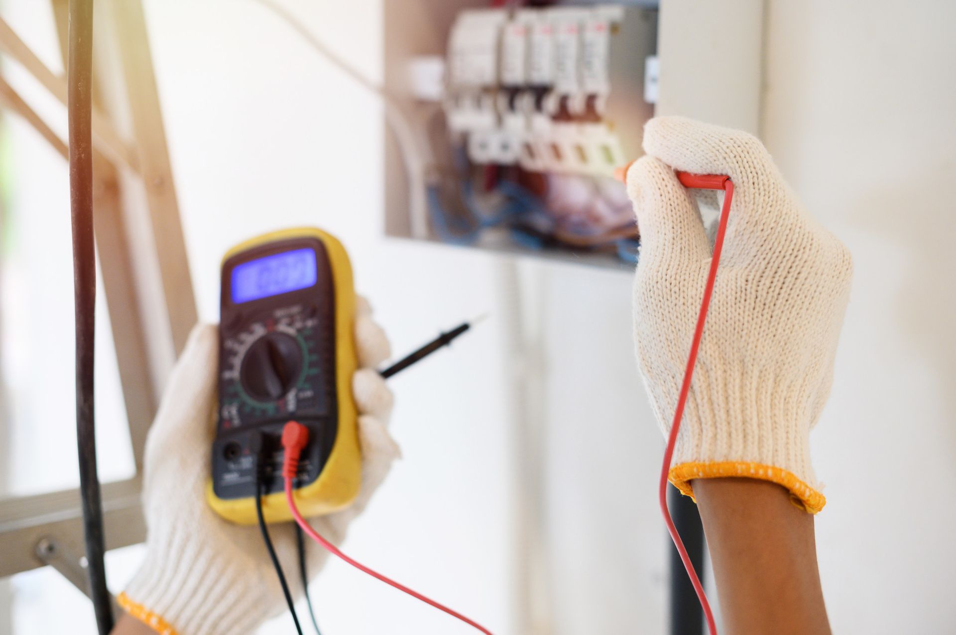 A person is using a multimeter to test a wire.